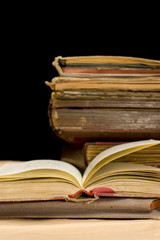 Pile of old books on black background