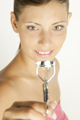 portrait of young woman with eyelash tweezers