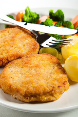 Fried pork chop  with boiled potatoes and vegetables