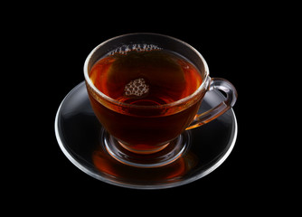 Glass cup of tea isolated on black