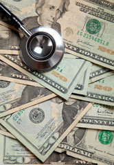 background of twenty dollar bills with a stethoscope