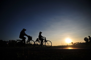 Fototapeta na wymiar sunset and people cycling in the countryside