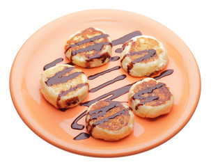 cheese pancakes with chocolate syrup on orange plate