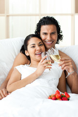 Happy couple drinking Champagne with strawberries