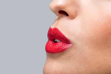 Obraz premium Close up red lips blowing a kiss