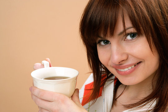 Portrait of young happy woman holding cup with tea
