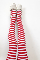 head over heels. female legs in stripy stockings;