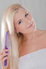 Young healthy woman brushing beautiful hair