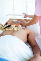 A doctor performing a CPR with a defibrillator on a patient - obrazy, fototapety, plakaty