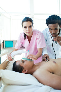 A doctor and a nurse resuscitating a male patient