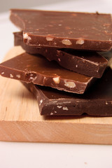 Pieces of chocolate with nuts on a wooden board