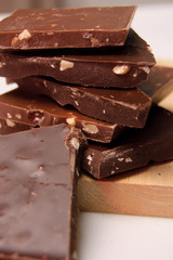 Pieces of chocolate with nuts on a wooden board