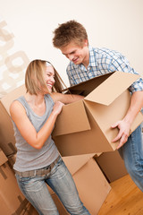 Fototapeta na wymiar New house: Young couple moving box, unpacking