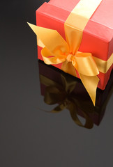 Red gift boxes with gold ribbon on black reflective background