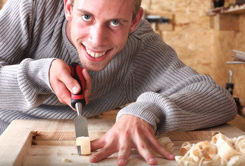 Young carpenter with gad working and smiling