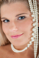 Young healthy woman with pure skin and pearls