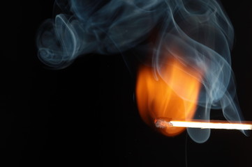 Rauchendes Z&uuml;ndholz vor schwarzem Hintergrund