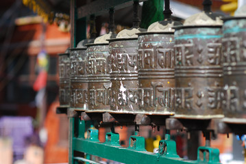 buddhist prayer wheels in a row