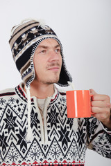 Young healthy winter man drinking hot coffee