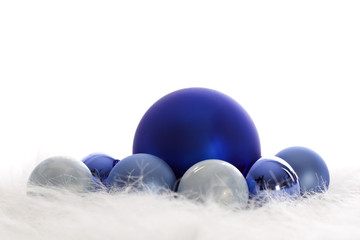 Arrangement of blue Christmas baubles on white fur