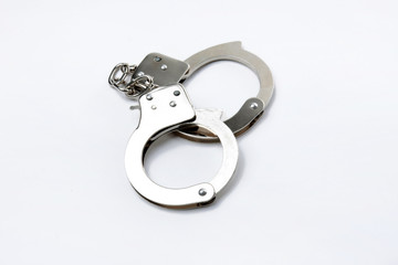 Pair of handcuffs isolated on a gray background..