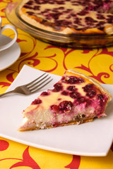 A piece of cherry pie on a white saucer