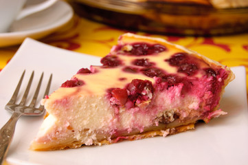 A piece of cherry pie on a white saucer