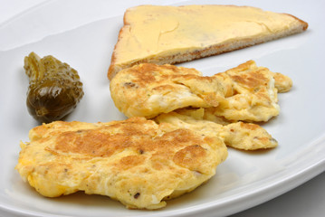 scramled eggs, gherkin and toast on a plate