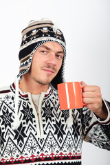 Young handsome man in winter clothes drink hot tea