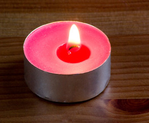 pink candle on wooden table