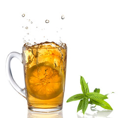 lemon dropped into tea cup with splash and mint