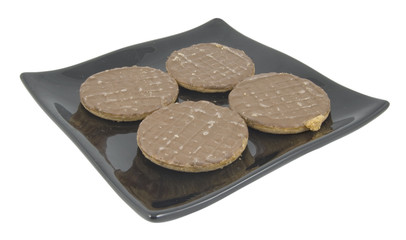 four chocolate biscuits / cookies on plate