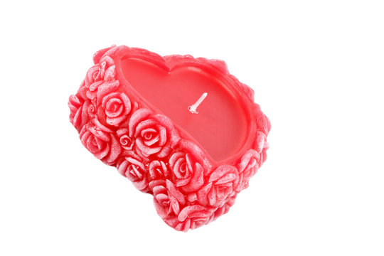 Heart-shaped candle with roses made of wax isolated on white