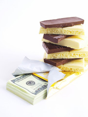 Pile of white and black chocolate on a pack of dollars