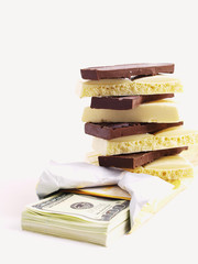 Pile of white and black chocolate on a pack of dollars
