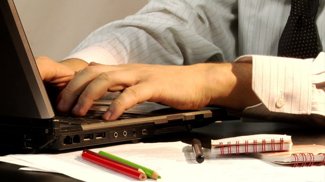 close-up man typing at laptop