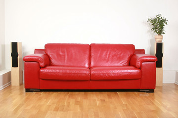 Red leather comfortable sofa in an interior