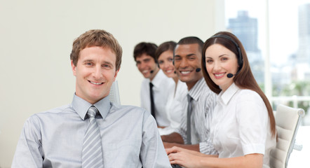 Young manager in front of his team in a call center