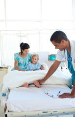 Obraz premium Smiling doctor examining little girl's feet