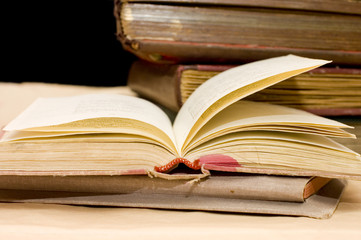 Pile of old books on black background