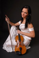 Young beautiful woman paying the violin