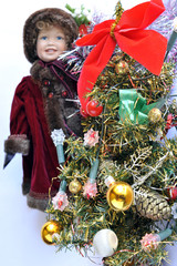 Christmas tree with a graceful baby doll in the background