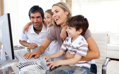 Caring parents teaching their children how to use a computer