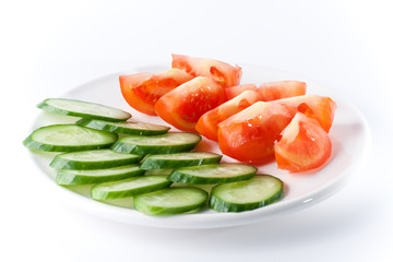 Cucumber and tomatoes on white plate