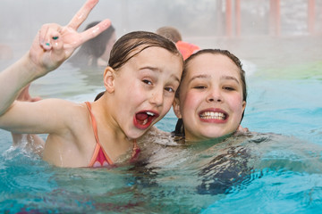 junge Mädchen schwimmen im Aussenbereich eines Thermalbades - obrazy, fototapety, plakaty
