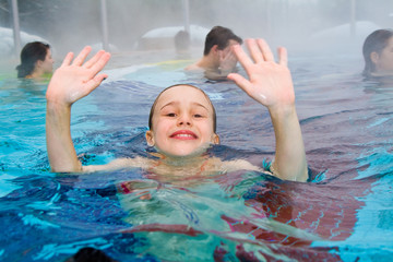 junge Mädchen schwimmen im Aussenbereich eines Thermalbades