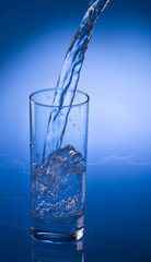 Pouring mineral water stream into a glass
