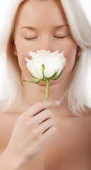 Obraz na płótnie Canvas Sexy blonde smelling a rose