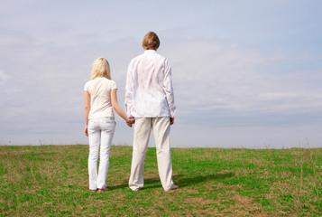 Guy and girl standing on the green meadow