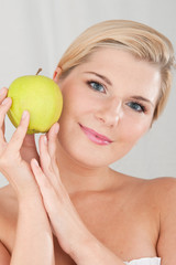 Young healthy smiling woman with green apple